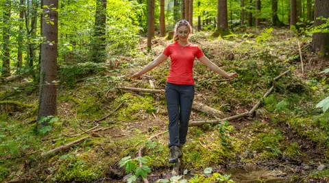 Frau spaziert im Wald am Woerthersee